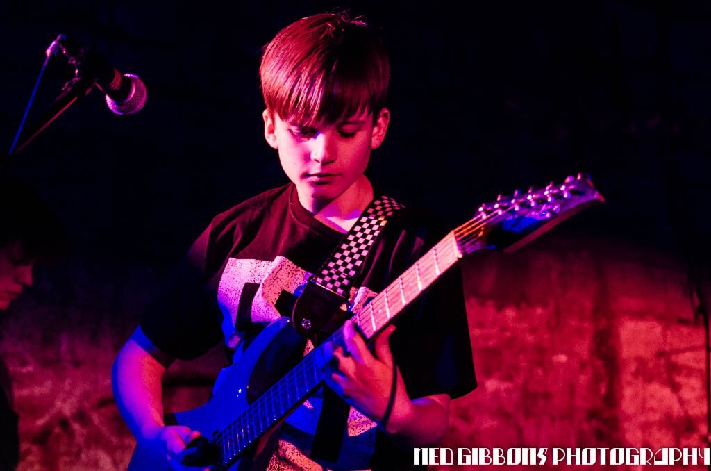 Young band performing under stage lights